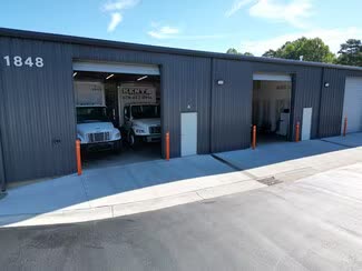 Two open bays at 1848 Chespark Dr with box trucks parked inside