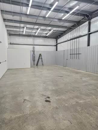 Empty unit interior with LED strip lighting and an open steel roof structure